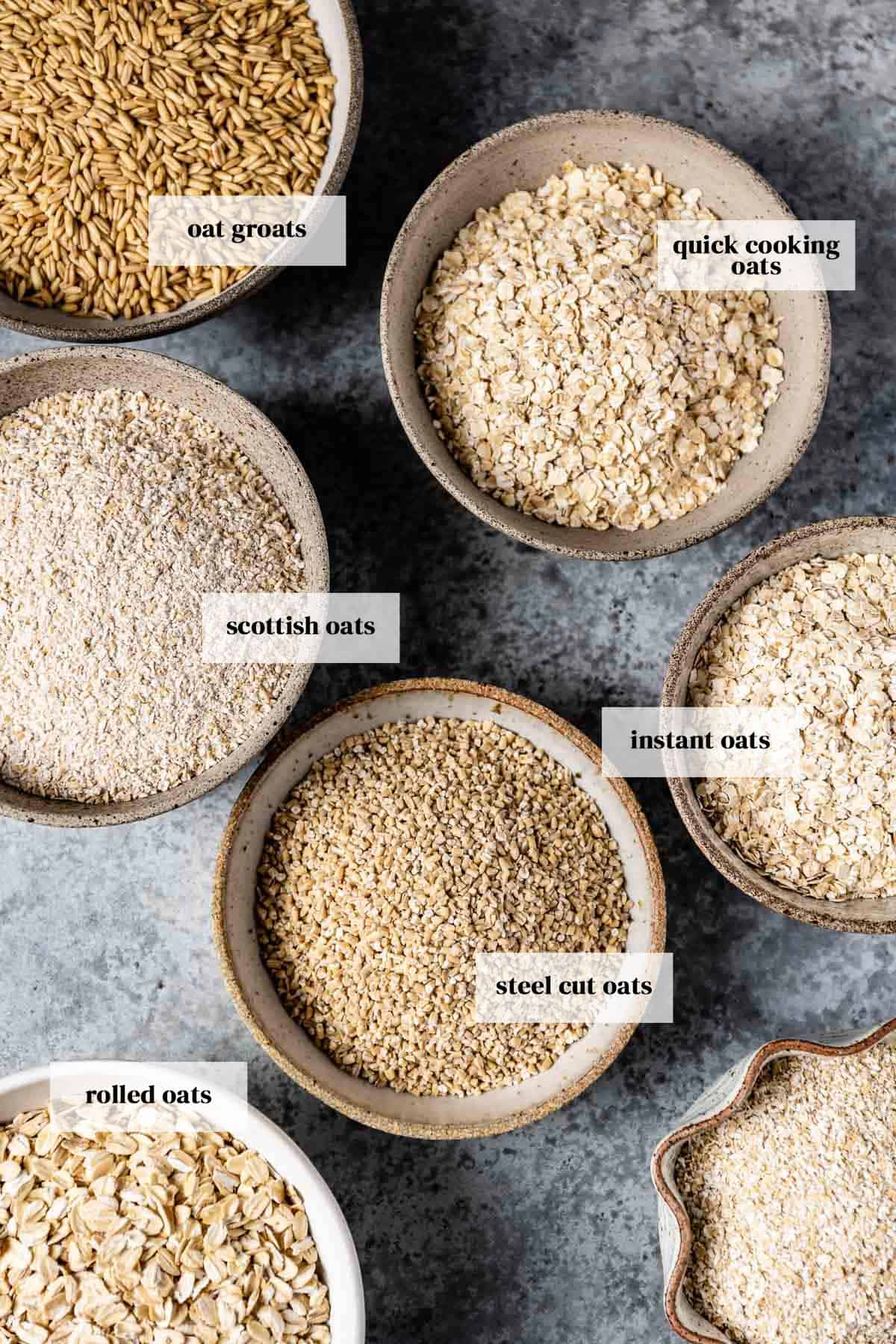 Different types of oats in small bowls with a text on each bowl.