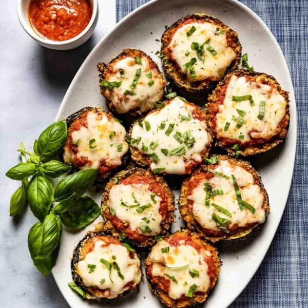 Air fryer eggplant parmesan garnished with basil from the top view.