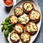 Air fryer eggplant parmesan slices placed in an oval plate and garnished with basil.