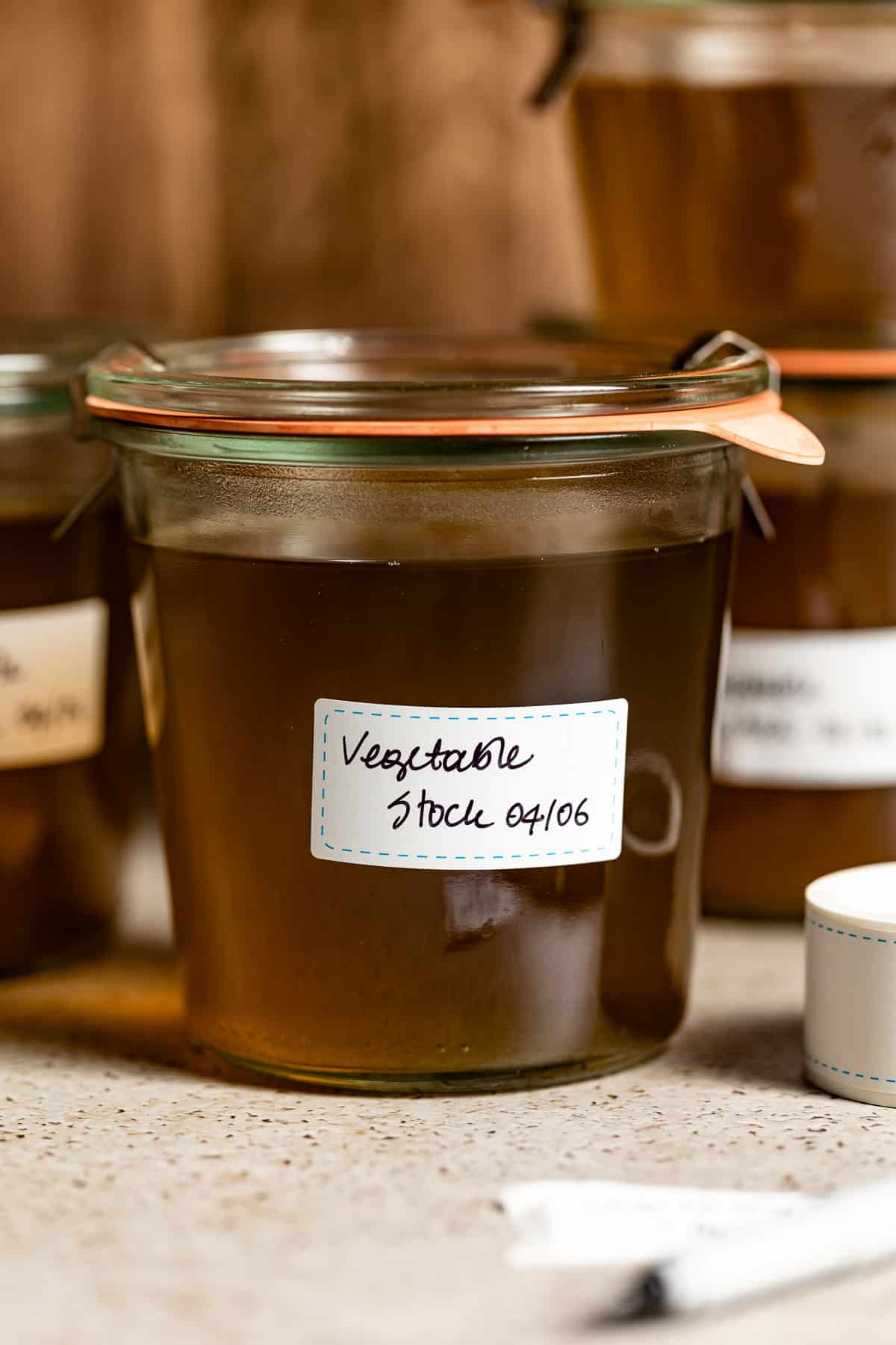 Veggie scrap stock in a jar labeled with the date.