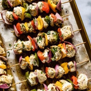 Oven chicken kabobs in a baking sheet from the top view.