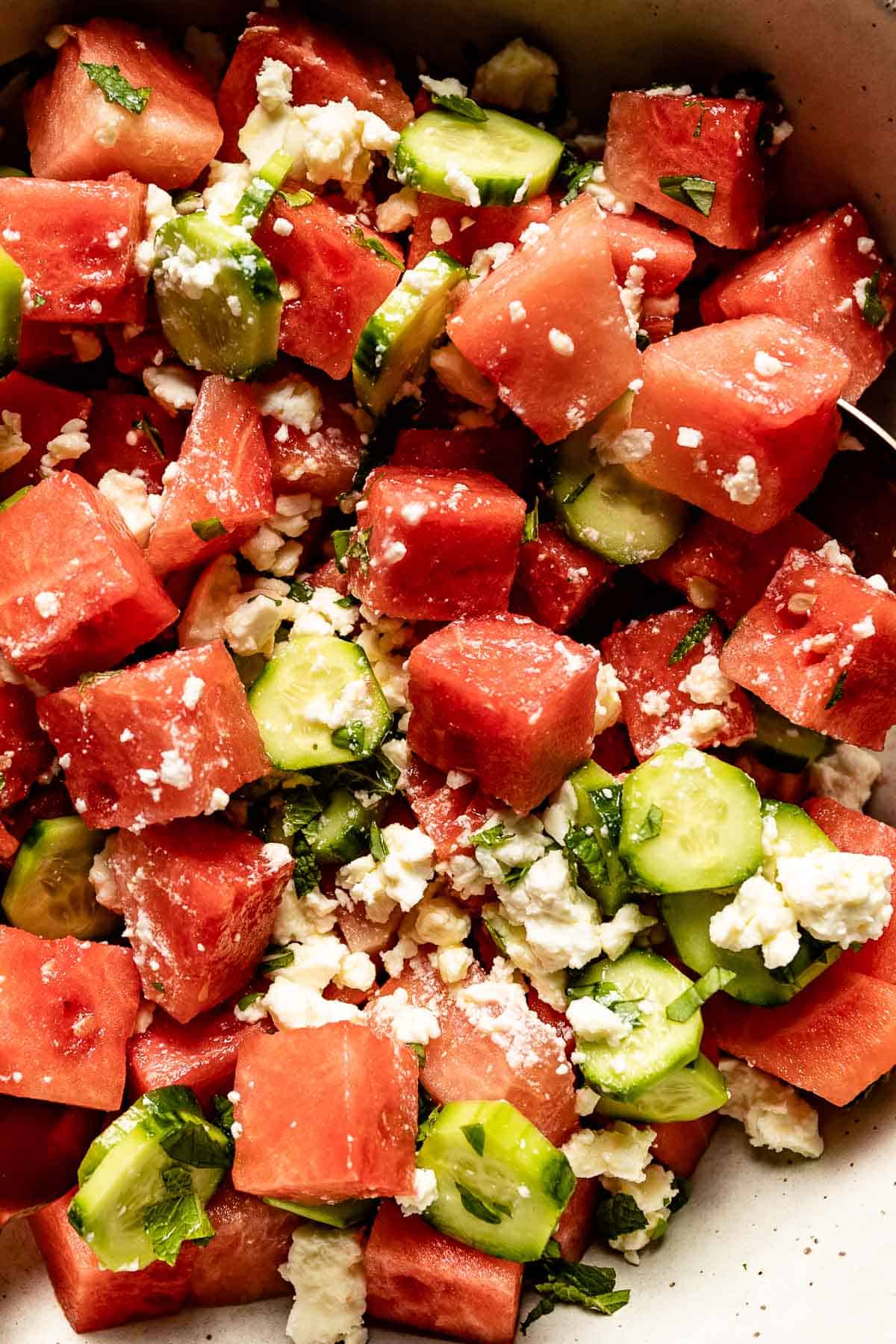 A close up of watermelon feta basil balsamic salad in a bowl.