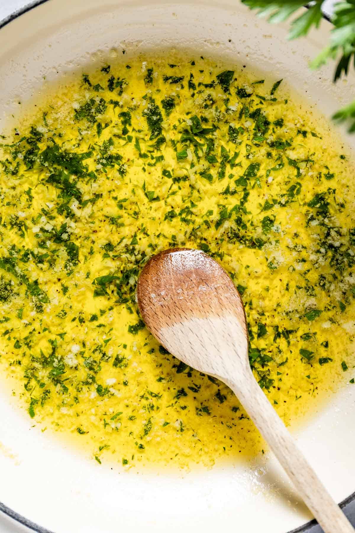 Butter and garlic sauce in a skillet with a wooden spoon.