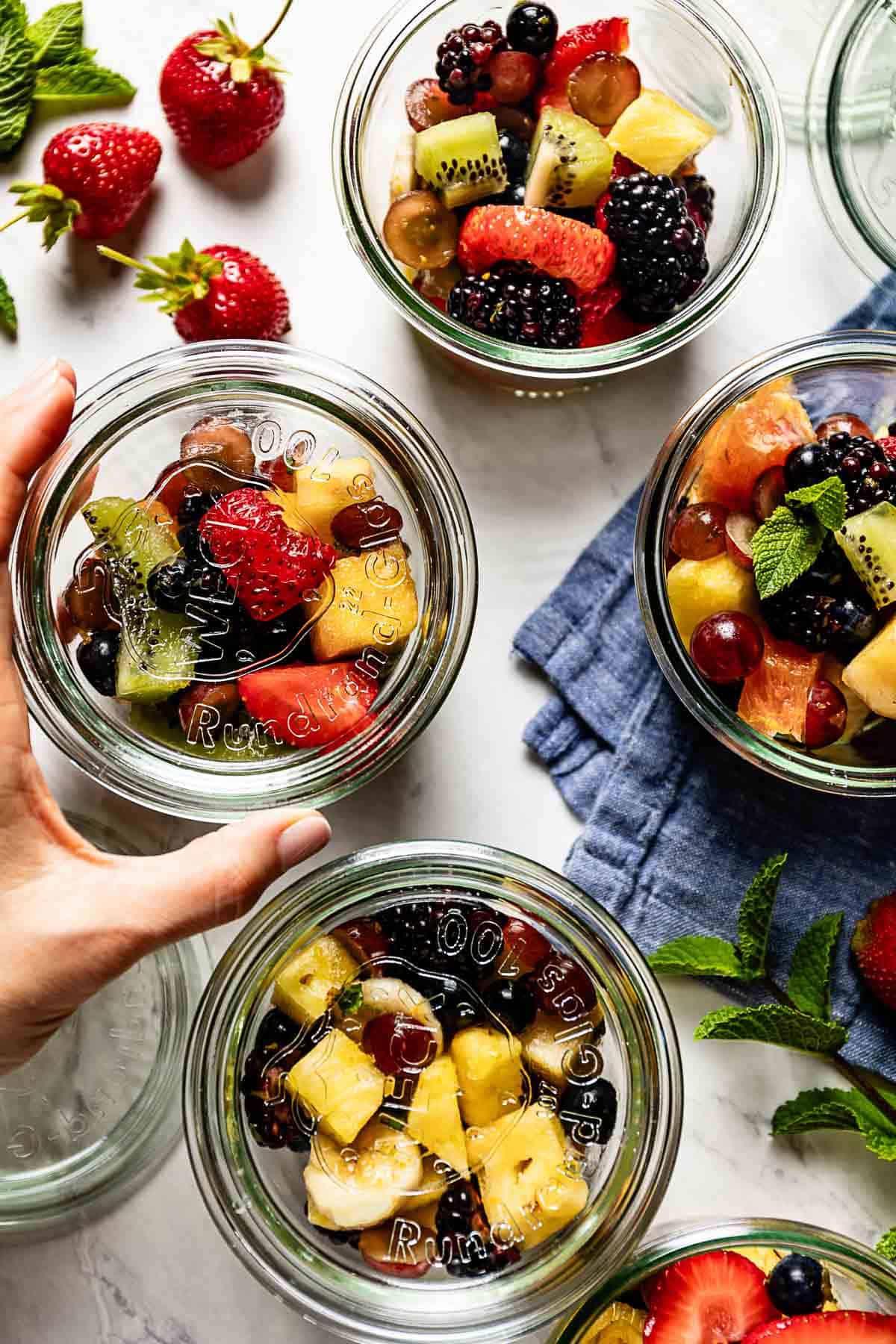 Breakfast fruit placed in glass jars from the top view.