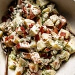 Red skinned potato salad with bacon in a bowl from the top view.