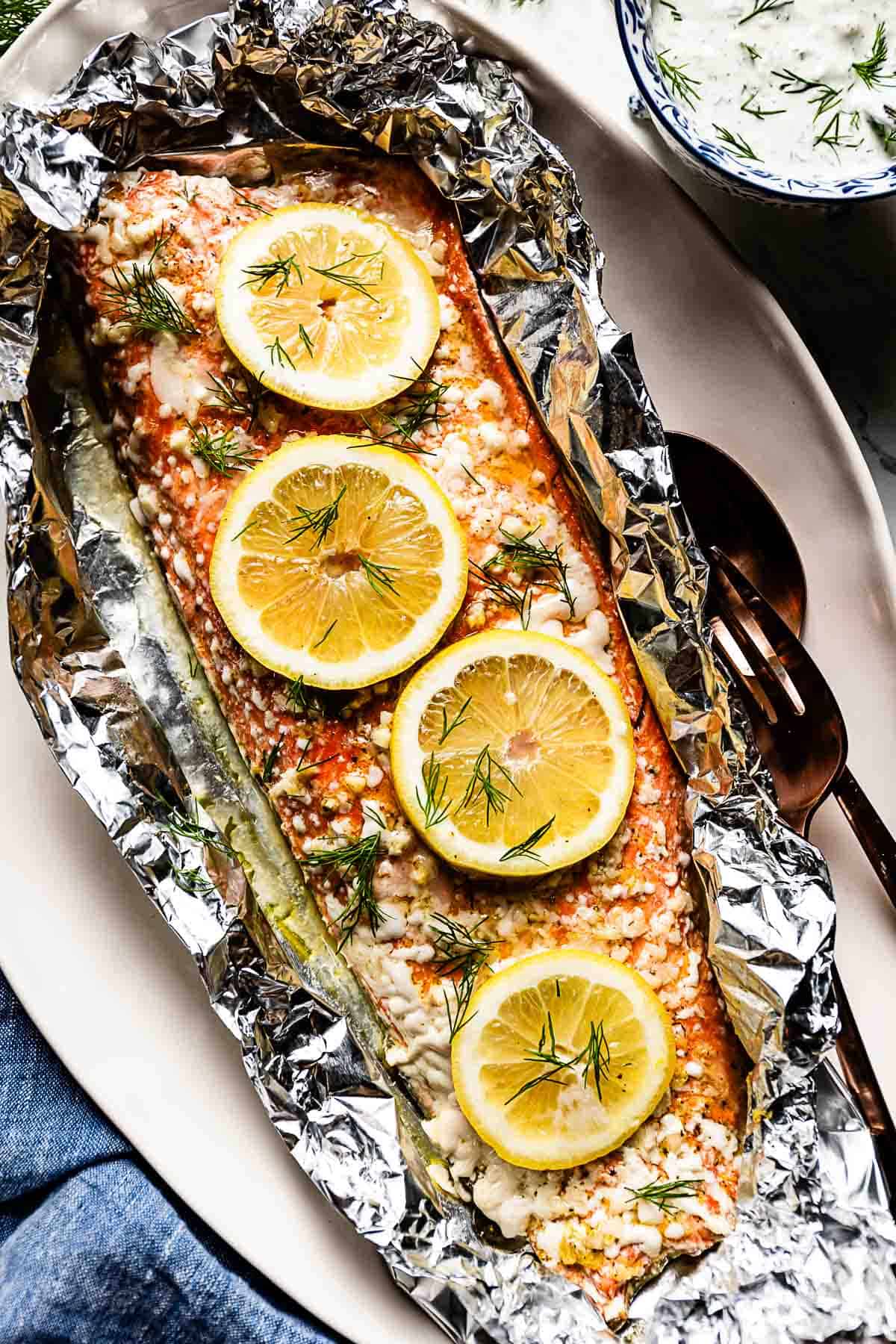 Baked Sockeye Salmon in foil garnished with lemon slices.