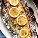 Baked Sockeye Salmon in foil garnished with lemon slices and minced garlic.
