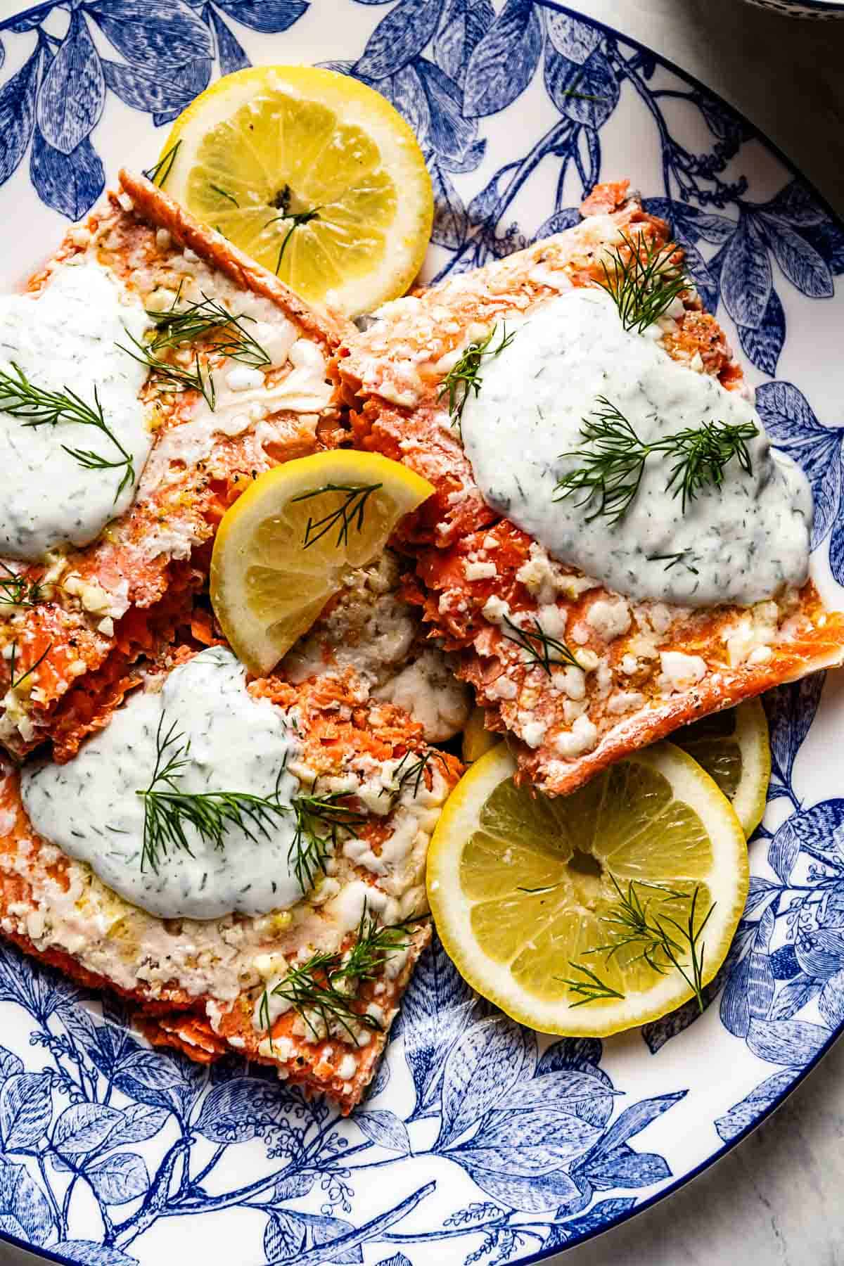 Baked Wild Alaskan salmon garnished with yogurt dill sauce from the top view.