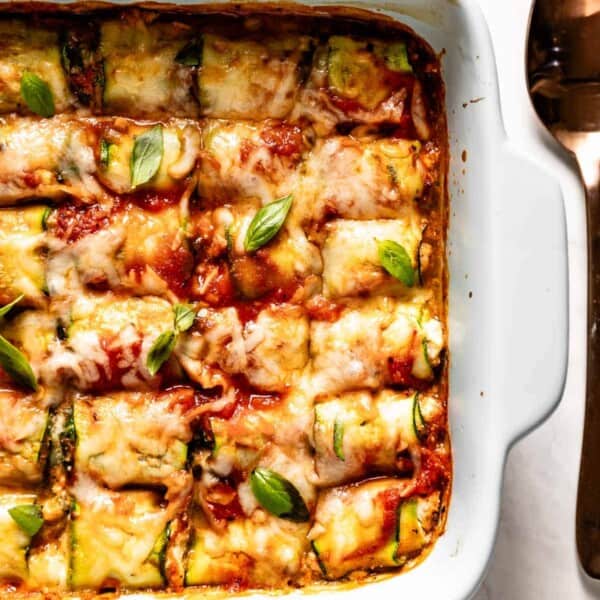 Zucchini lasagna rolls in a baking dish from the top view.