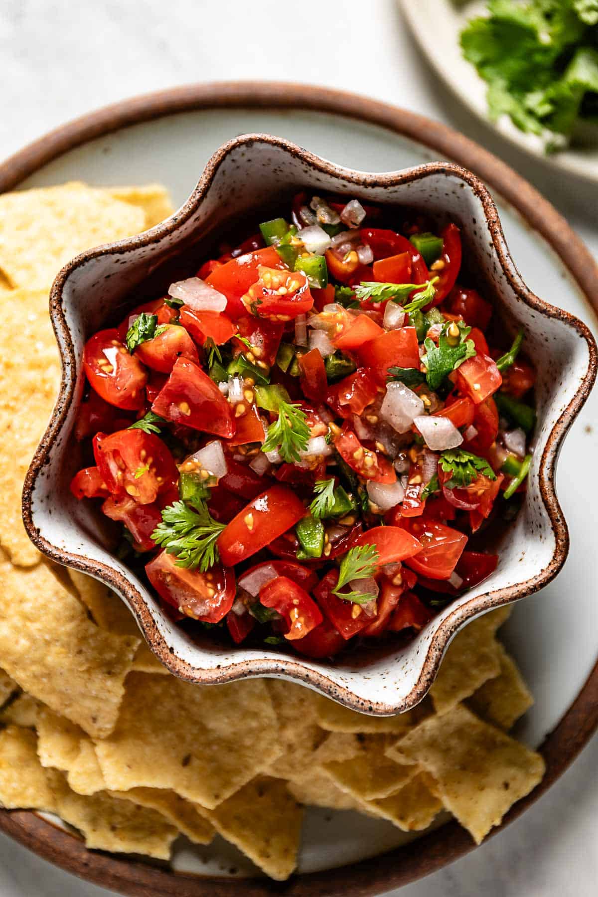 A bowl of salsa with cherry tomatoes from the top view.