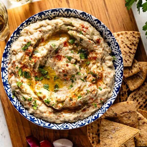 Baba ganoush recipe served in a bowl with veggies and pita bread on the side.