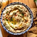 Baba ganoush in a bowl with pita wedges on the side.