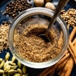 Baharat spices mixed in a bowl with a spoon in the bowl.