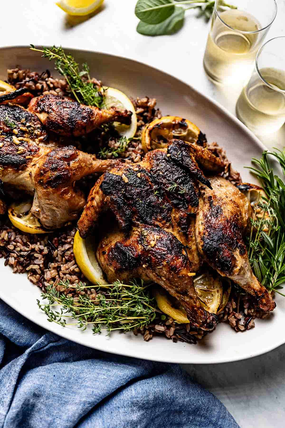 Grilled Cornish game hens on a bed of wild rice.
