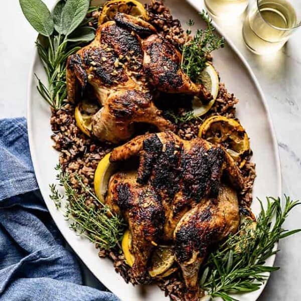 Grilled cornish hens on a big plate from the top view.