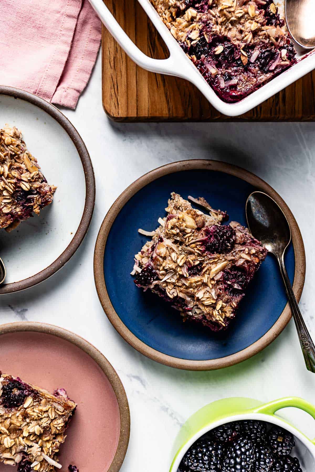 Baked blackberry oatmeal cut into slices and served on small plates.
