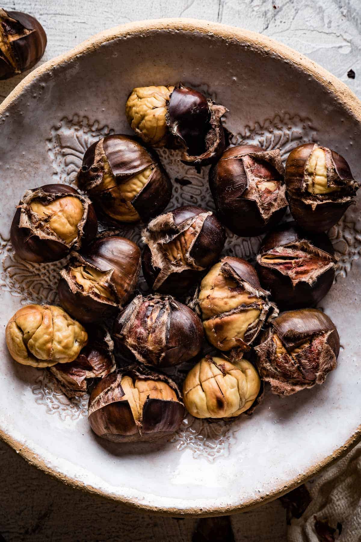 Oven roasted chestnuts in a bowl.