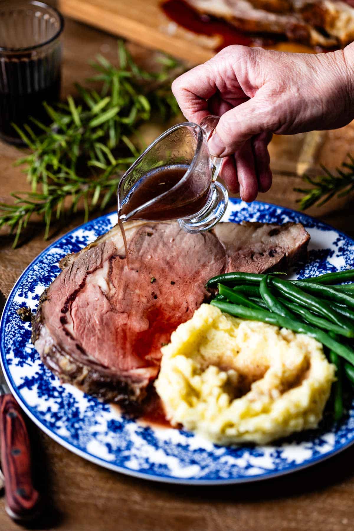 Prime Rib Au jus being drizzled on a slice of prime rib.