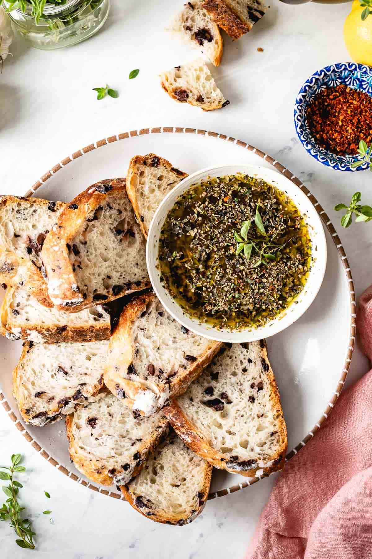 Garlic bread dipping sauce in a bowl with bread on the side.