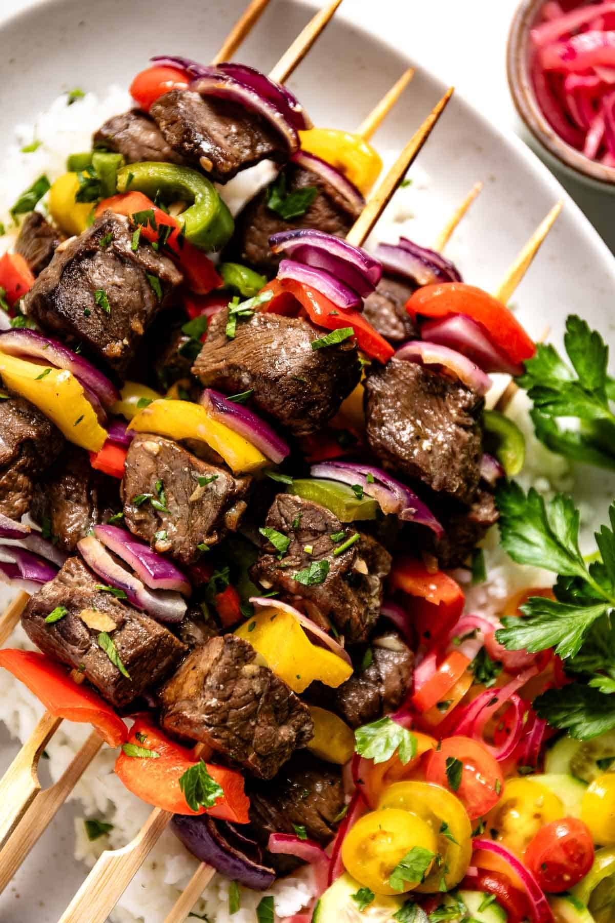 Beef shish kabob skewers on a bed of rice from the top view.