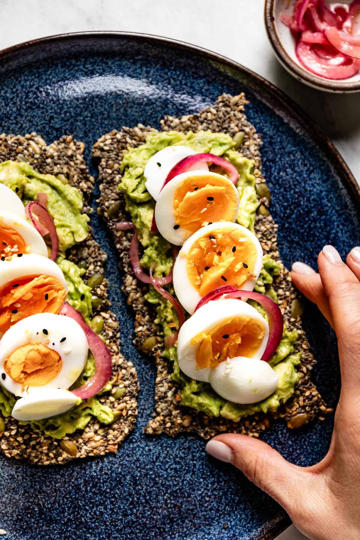 Avocado and egg toast made using homemade crackers with seeds.