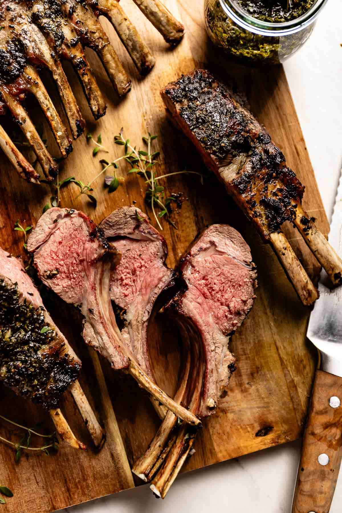 Grilled Frenched rack of lamb on a cutting board.