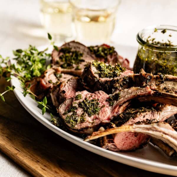 Grilled rack of lamb with mint sauce on the side.