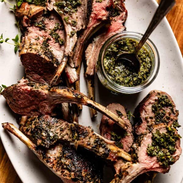 Mint sauce for lamb in a jar with rack of lamb on the side.