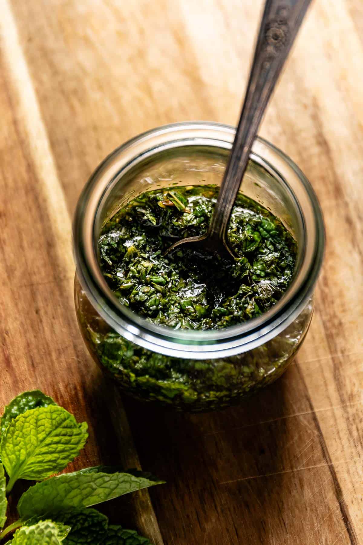 Mint sauce for lamb in a small jar with a spoon.