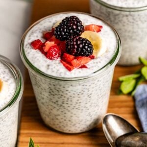 Chia pudding with yogurt topped off with berries in a glass jar.