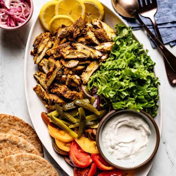 Chicken shawarma on a large plate served with toppings.