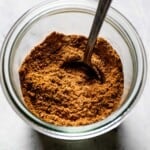 Shawarma spice mix in a jar with a spoon.