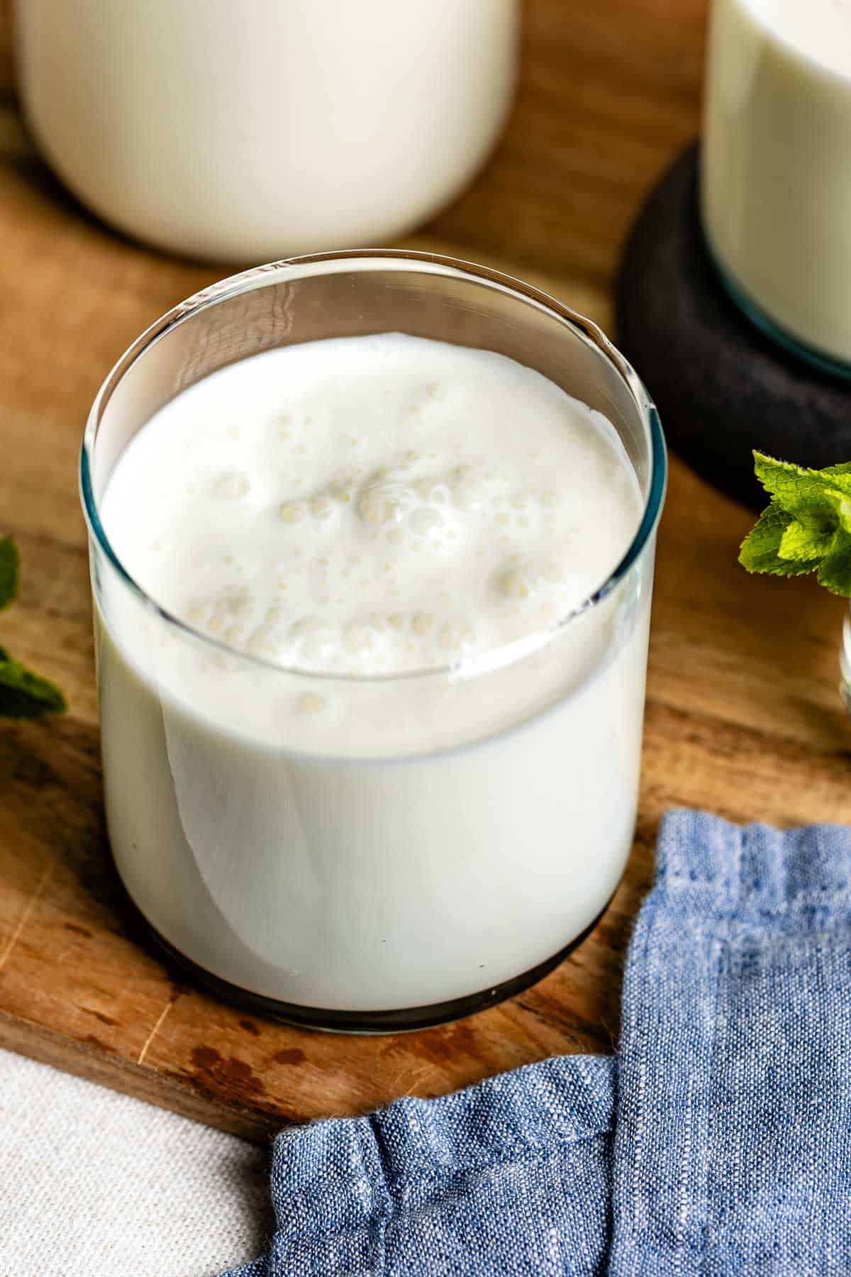 A glass of froth ayran in a glass from the front view.