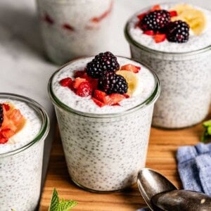 Yogurt chia pudding garnished with berries in glass jars.