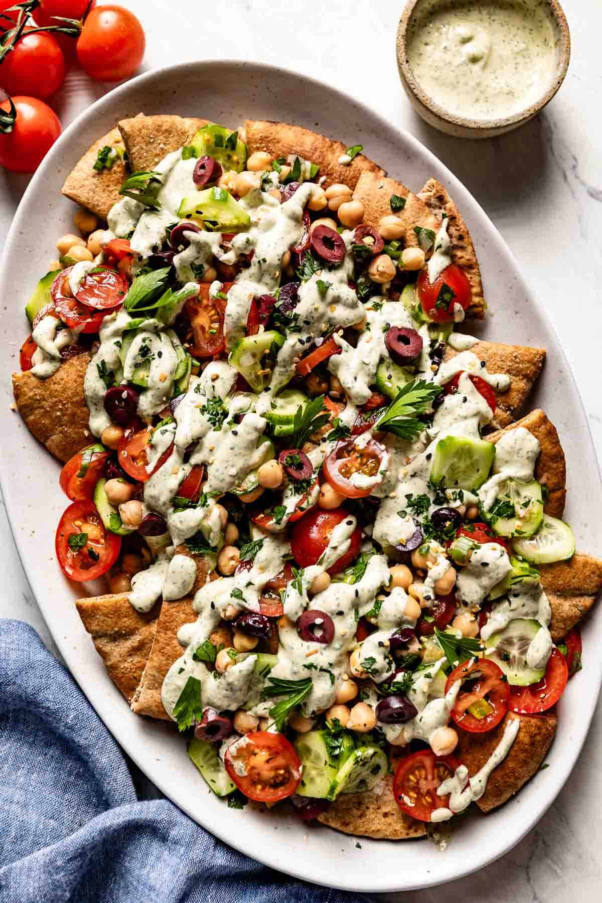 Vegan Turkish nachos drizzled with tahini dressing from the top view.