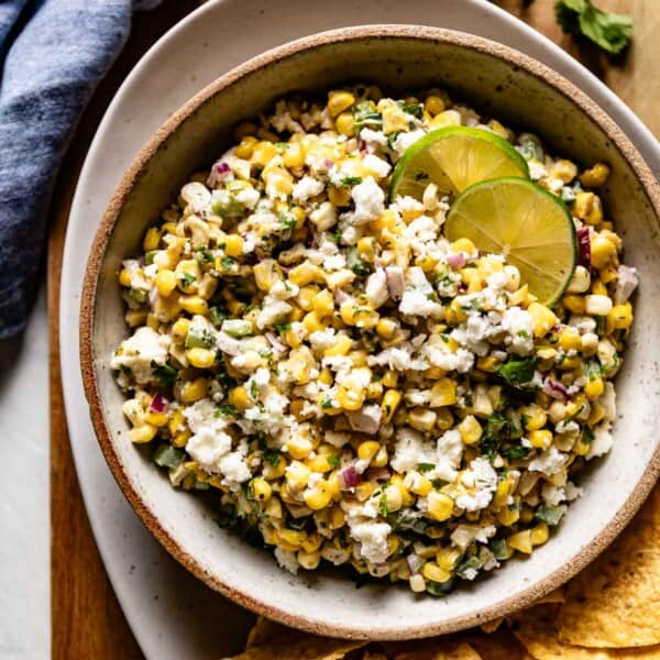 Mexican street corn dip served with chips on the side in a bowl.
