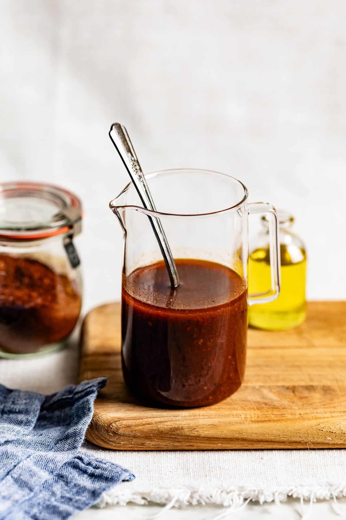 Harissa Vinaigrette in a jar with a spoon in it from the front view.