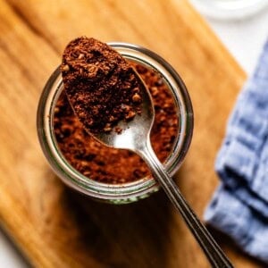 Harissa powder in a jar with a spoonfull.