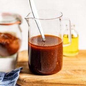 Harissa vinaigrette in a jar with a spoon.