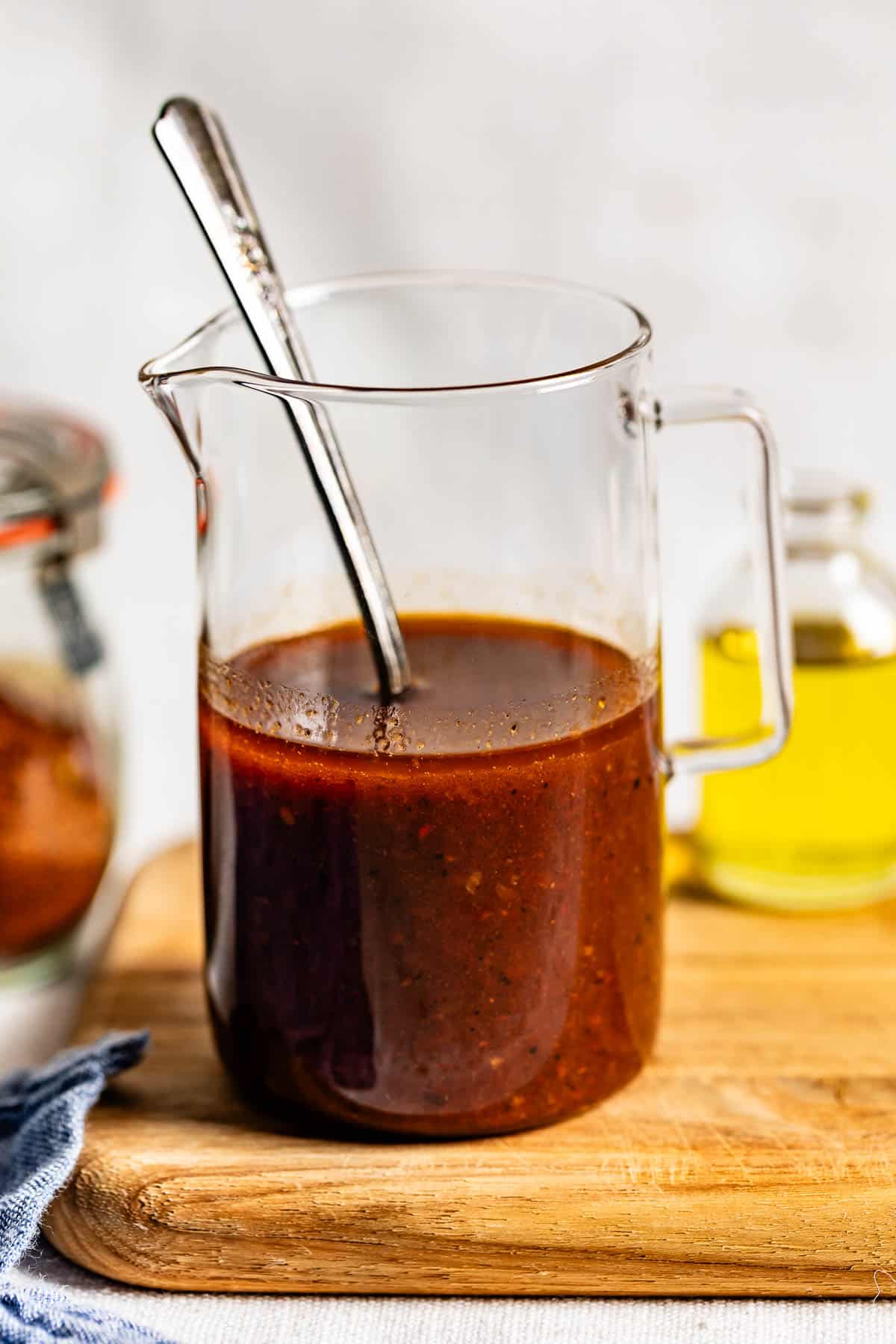 Cava copycat hot harissa vinaigrette in a glass jar with a spoon.