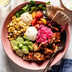 A bowl of food from the top view pita bread on the side.