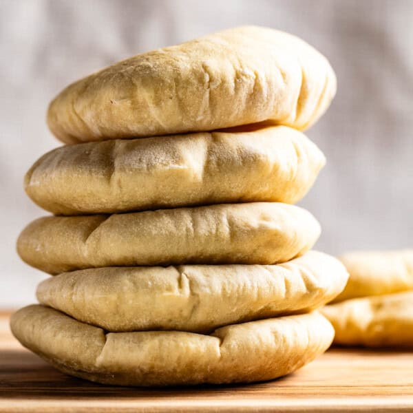 Pita bread loaves on a wooden cutting board.