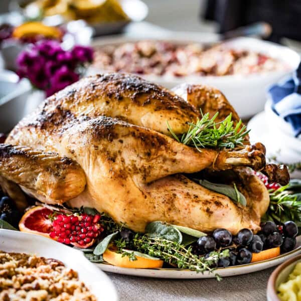 Herb roasted turkey is garnished with fruit on a plate.