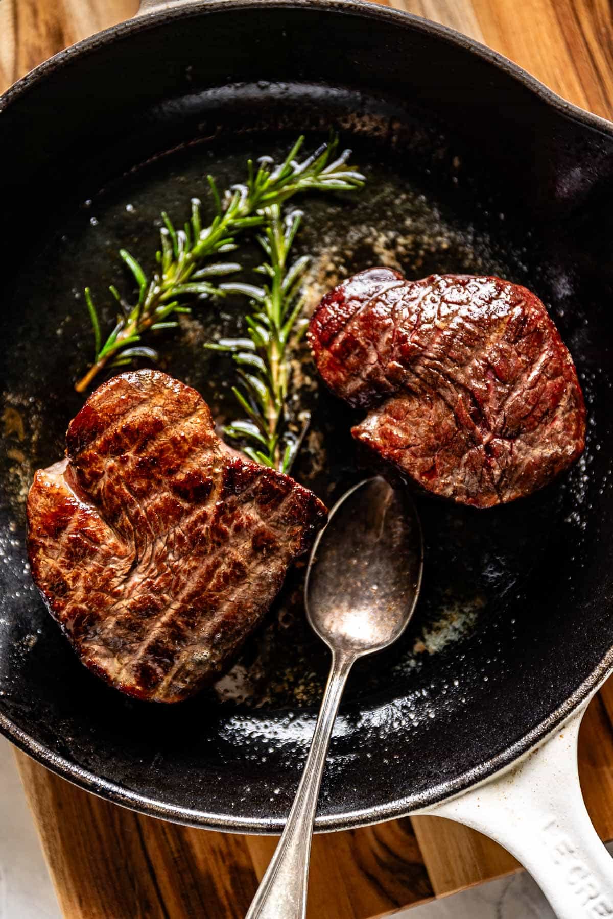 Reverse seared tenderloin steak in a cast iron skillet from the top view.