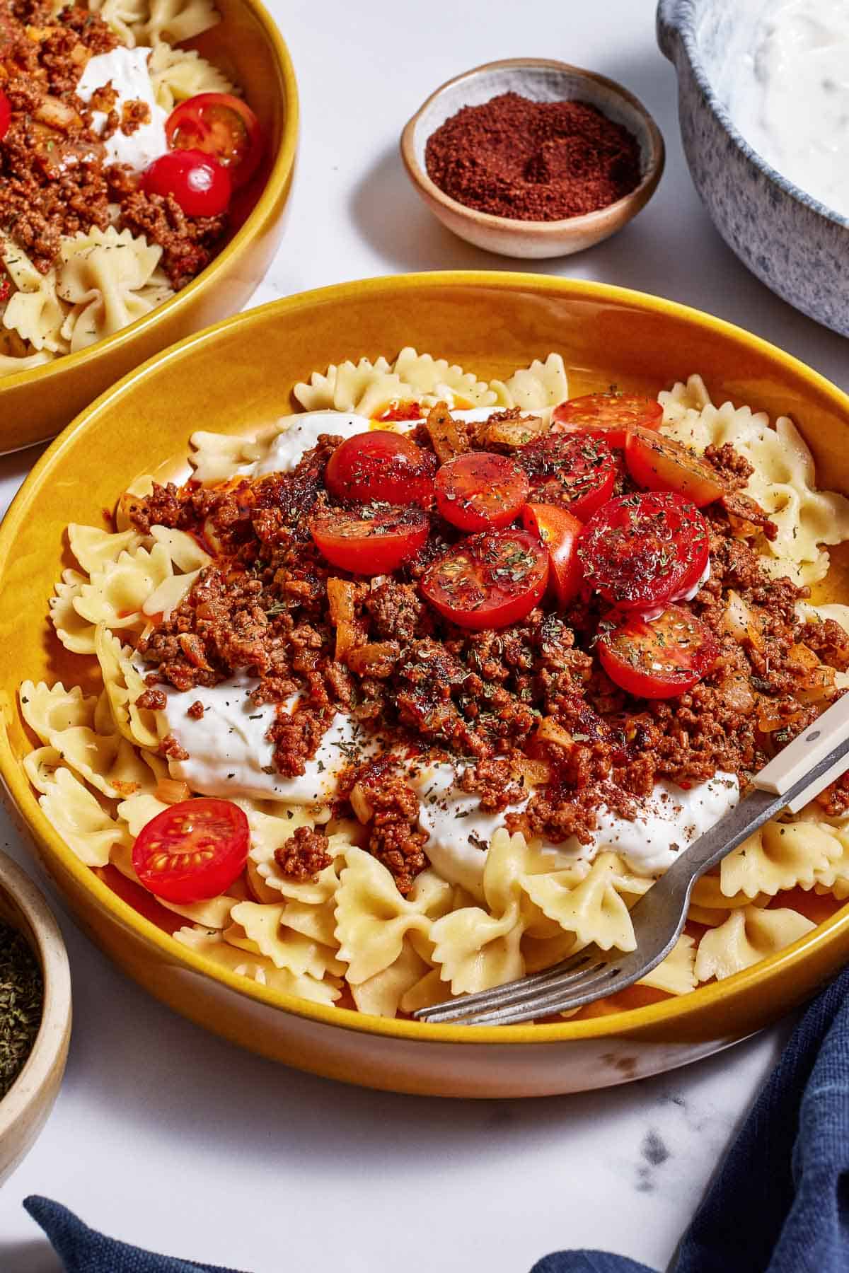 Pasta Turkish garnished with dried mint and tomatoes from the front view.