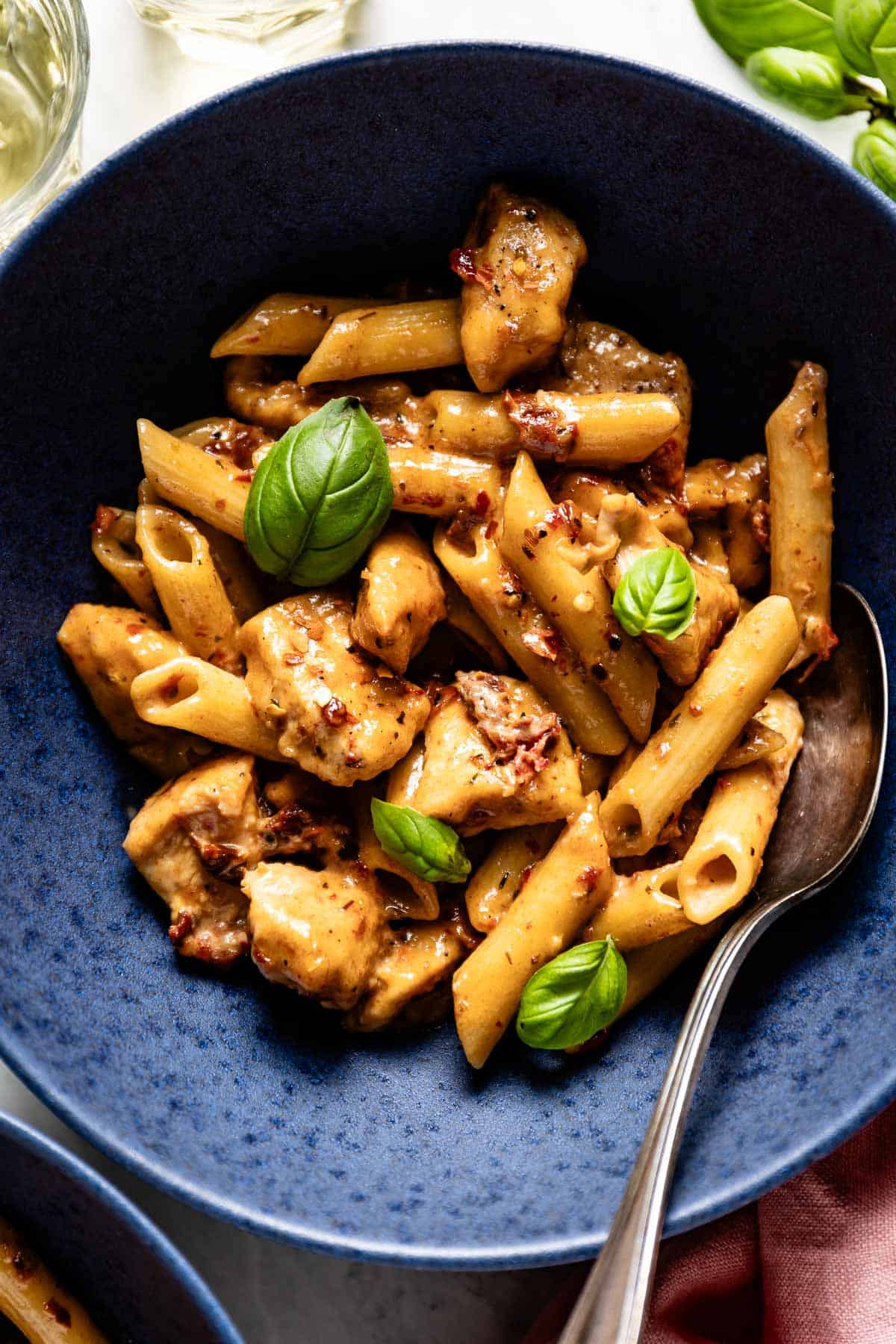 Marry me chicken pasta in a bowl with a spoon on the side.