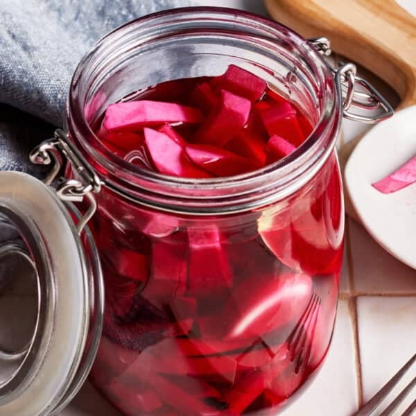 Pickled turnips in a jar with the lid open.