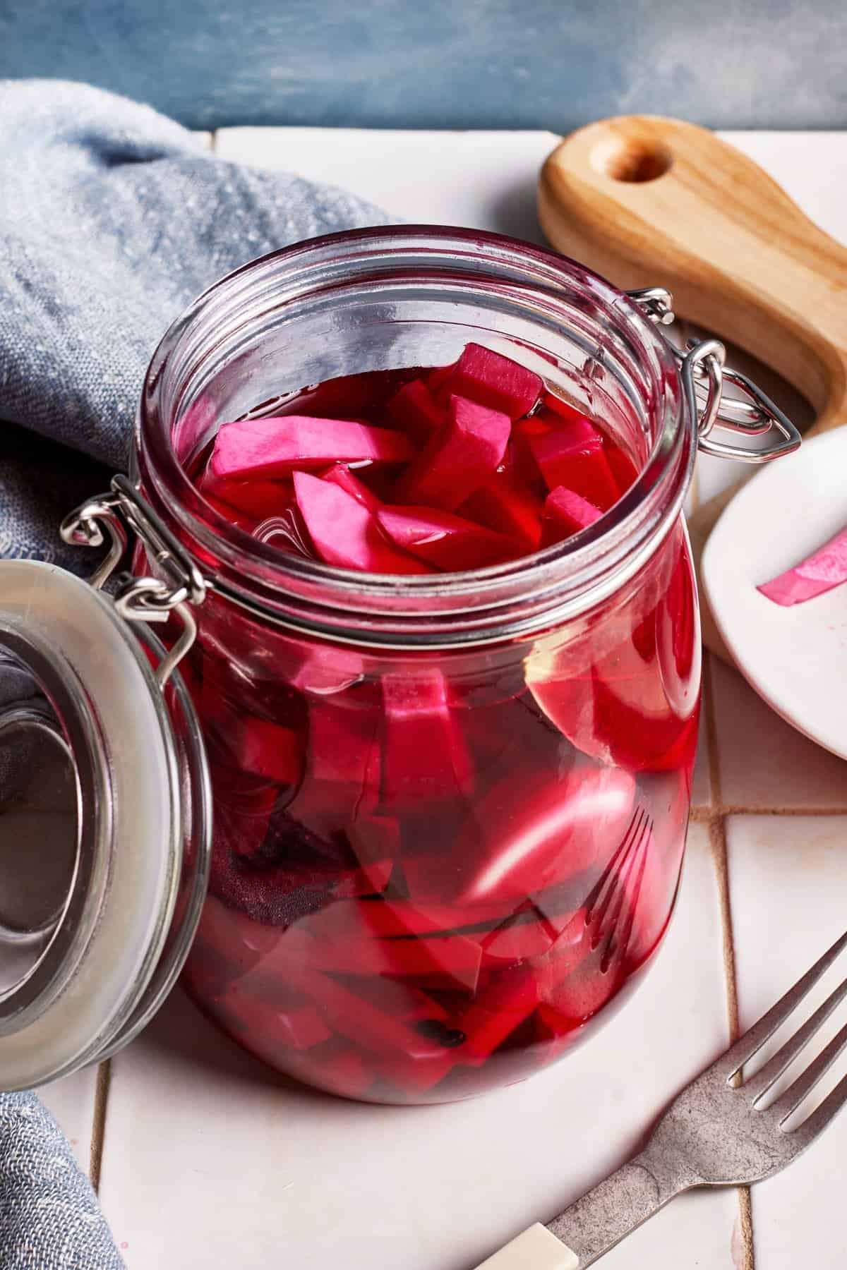 Pink pickled turnips in a glass jar.