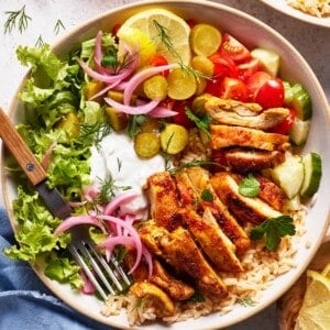 Chicken shawarma bowl garnished with pickled red onions from the top view.