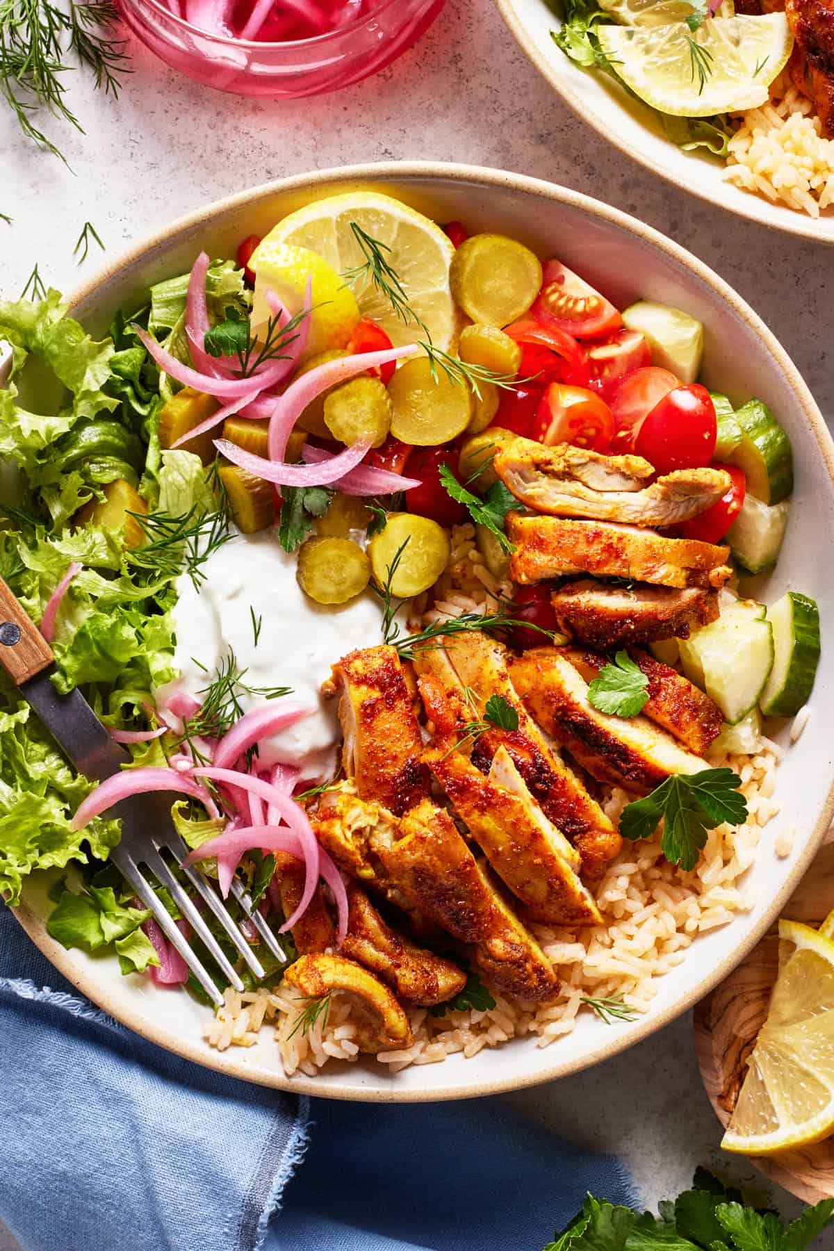 Chicken shawarma bowl served with rice and toppings from the top view.